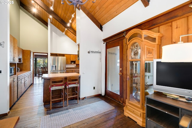 kitchen with dark wood-type flooring, stainless steel fridge, high vaulted ceiling, and wood ceiling