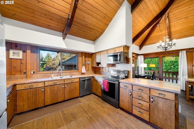 kitchen with high vaulted ceiling, decorative light fixtures, stainless steel appliances, and beamed ceiling