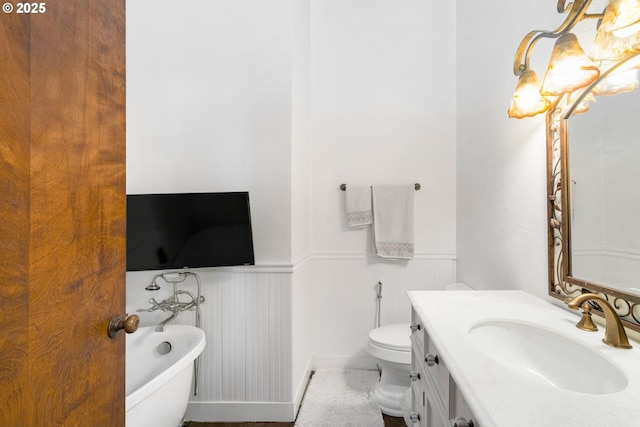 bathroom with vanity, a tub, and toilet