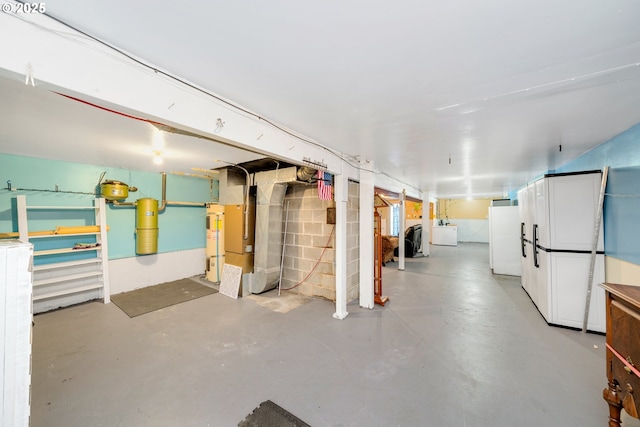 basement with washer / clothes dryer and white fridge