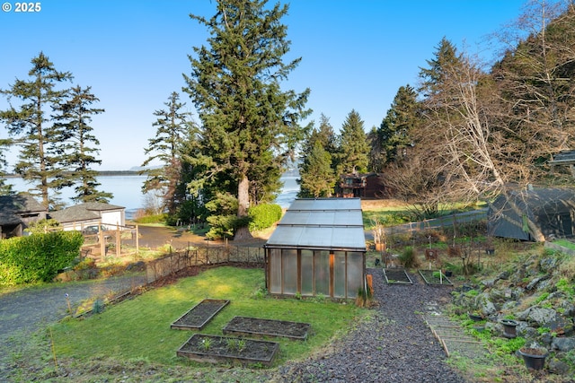 view of yard featuring a water view and an outbuilding