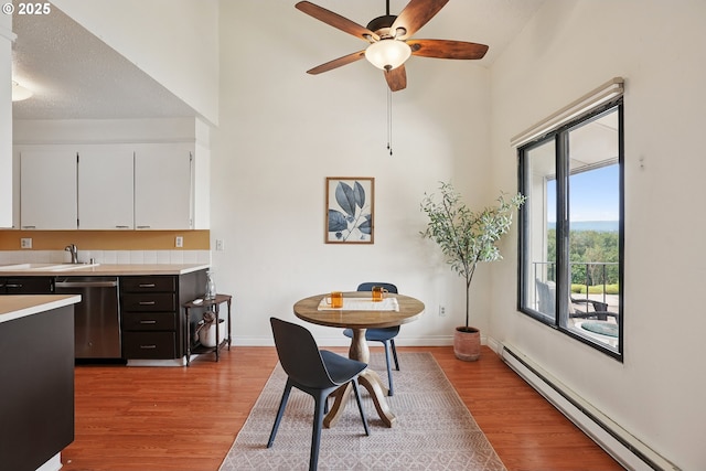 5585 E Evergreen Blvd, Vancouver, WA 98661 - dining space featuring a baseboard heating unit, a towering ceiling, light wood-type flooring, and ceiling fan