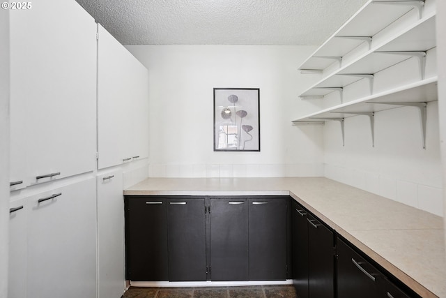 5585 E Evergreen Blvd, Vancouver, WA 98661 - kitchen featuring a textured ceiling, light countertops, open shelves, and dark cabinetry