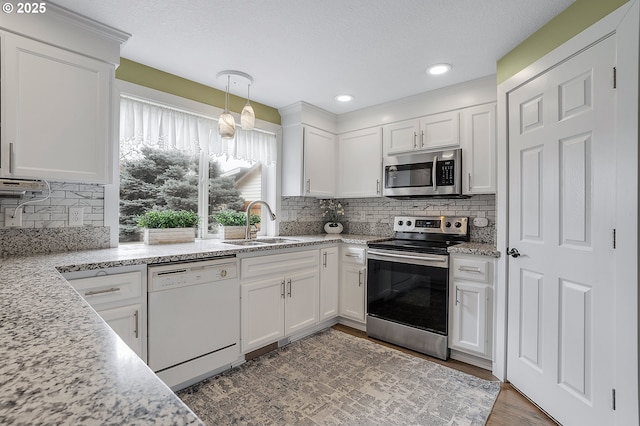 11619 NE 102nd Cir, Vancouver, WA 98662 - kitchen featuring white cabinets, a sink, stainless steel appliances, wood finished floors, and backsplash