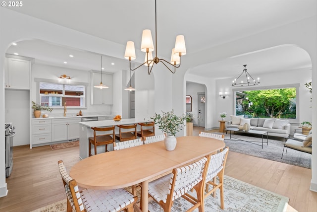 625 NE 69th Ave, Portland, OR 97213 - dining space featuring a chandelier, arched walkways, light wood finished floors, and recessed lighting