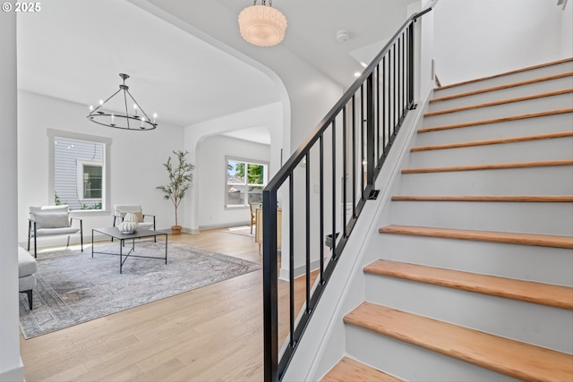 625 NE 69th Ave, Portland, OR 97213 - stairs featuring arched walkways, a chandelier, and wood finished floors