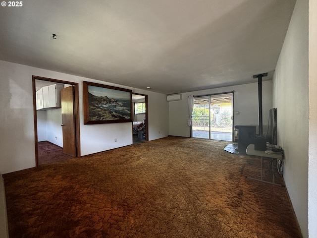 47858 W 1st St, Oakridge, OR 97463 - unfurnished living room featuring a wood stove, carpet, and an AC wall unit