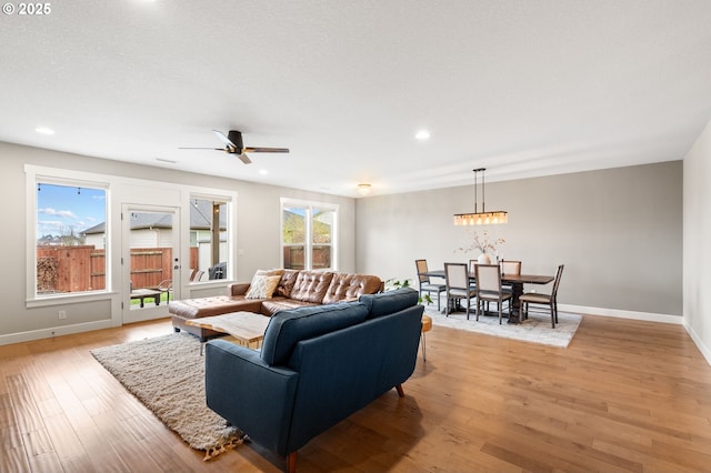 living room with ceiling fan and light hardwood / wood-style flooring