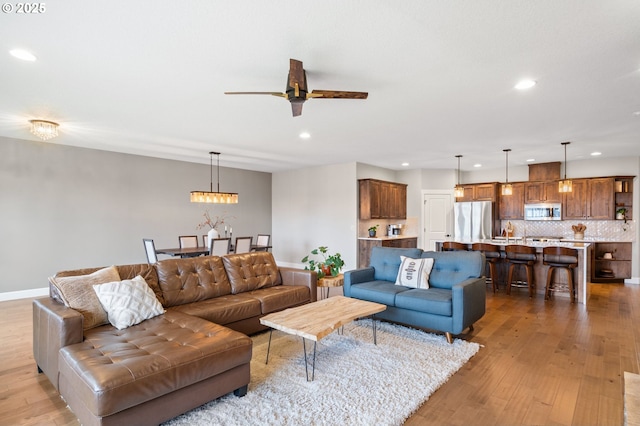 living room featuring ceiling fan and light wood-type flooring