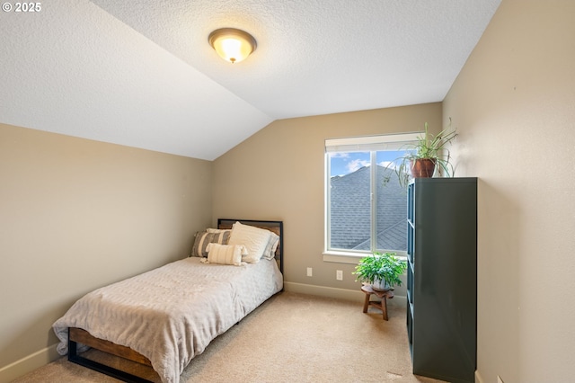 bedroom featuring a textured ceiling, light colored carpet, and vaulted ceiling