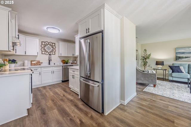 1109 SW 15th St, Lincoln City, OR 97367 - kitchen with stainless steel appliances, open floor plan, custom range hood, dark wood-type flooring, and white cabinets