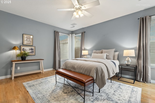 bedroom featuring ceiling fan, baseboards, and light wood-style flooring