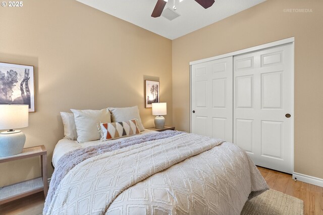 bedroom featuring a ceiling fan, light wood-style flooring, baseboards, and a closet