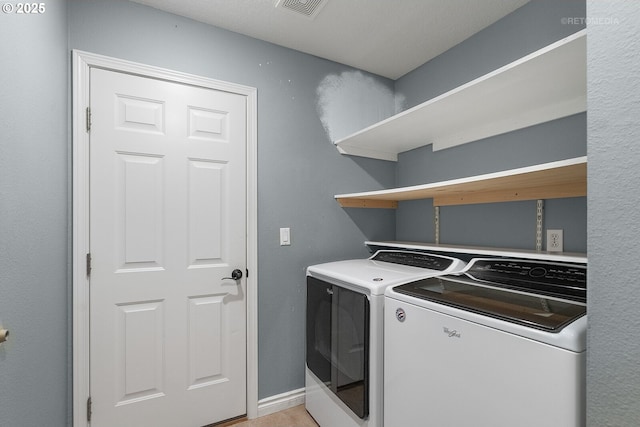 washroom with washer and clothes dryer, laundry area, visible vents, and baseboards