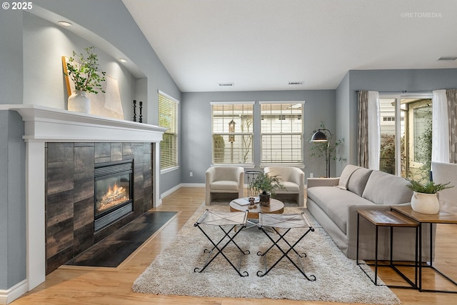 living room with visible vents, a healthy amount of sunlight, a fireplace, and wood finished floors