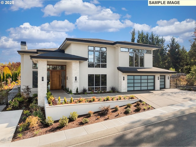 view of front of home with a garage, concrete driveway, a chimney, fence, and stucco siding