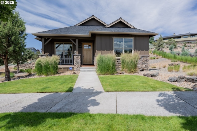 1202 SE Yarrow Ave, Madras, OR 97741 - view of front facade featuring board and batten siding, a front lawn, a shingled roof, and a porch