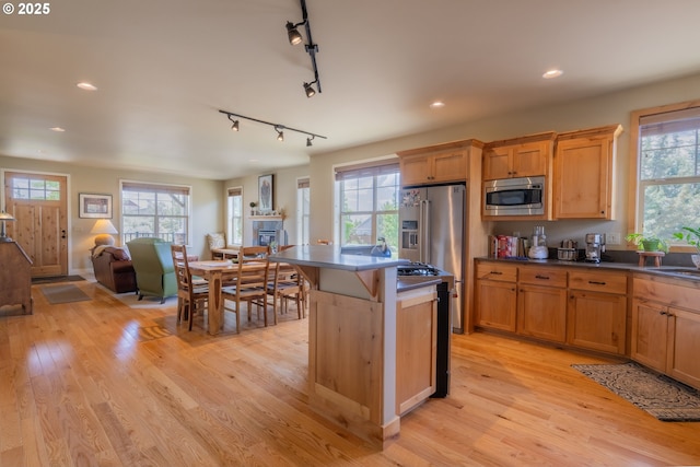 1202 SE Yarrow Ave, Madras, OR 97741 - kitchen with stainless steel appliances, dark countertops, track lighting, light wood-style floors, and open floor plan