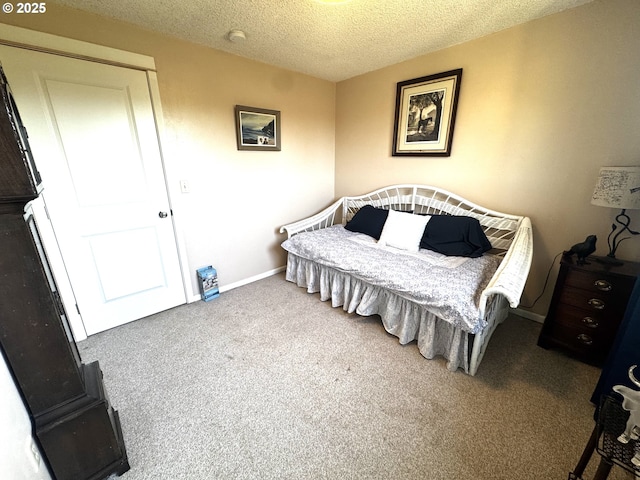 bedroom featuring baseboards, carpet flooring, and a textured ceiling