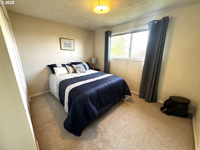 bedroom featuring baseboards, carpet, and a textured ceiling