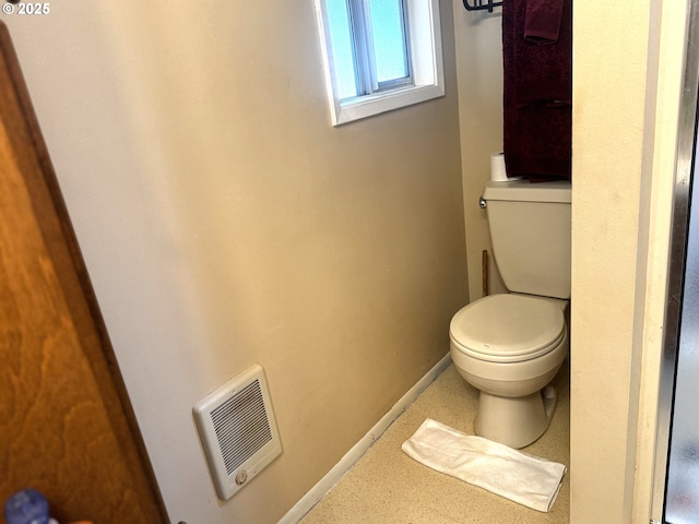 bathroom with baseboards, toilet, and visible vents