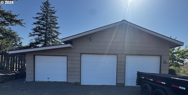 detached garage featuring fence