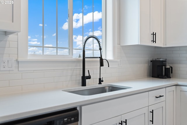 kitchen featuring backsplash, white cabinets, and stainless steel dishwasher