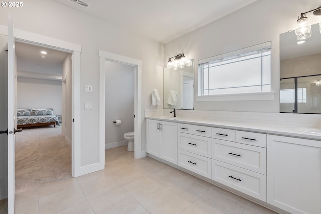 bathroom featuring vanity, tile patterned floors, backsplash, and toilet