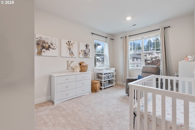 carpeted bedroom featuring a crib