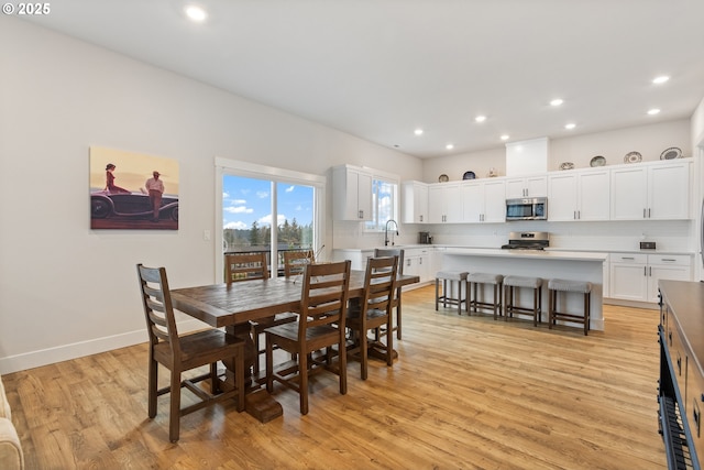 dining space with light wood-type flooring and sink