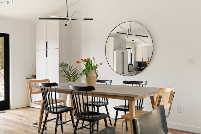 dining space featuring light wood-style floors and baseboards