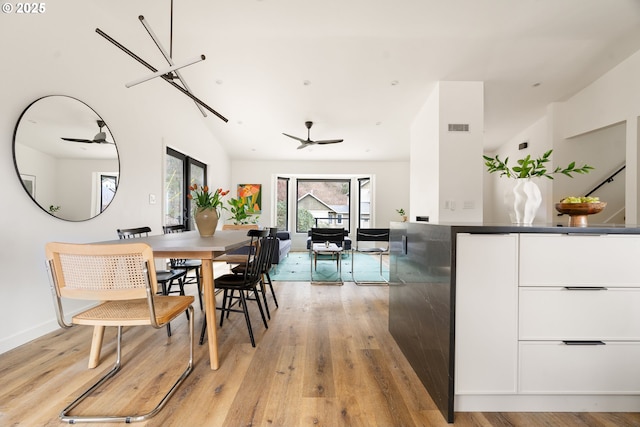 dining room featuring light wood-type flooring, visible vents, ceiling fan, and baseboards