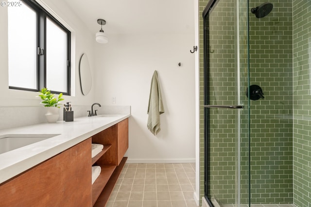 bathroom with tile patterned floors, a sink, a shower stall, and double vanity