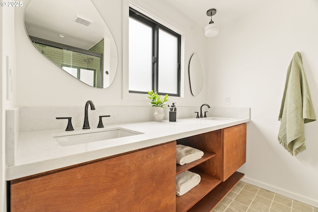 bathroom with an enclosed shower, visible vents, a sink, and double vanity