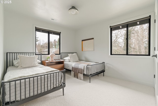 carpeted bedroom with multiple windows and visible vents