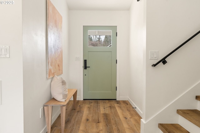 doorway to outside with light wood finished floors, stairs, and baseboards