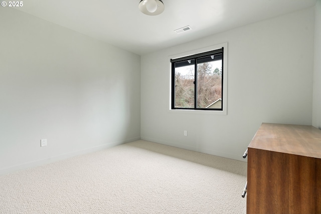 unfurnished room with carpet, visible vents, and baseboards