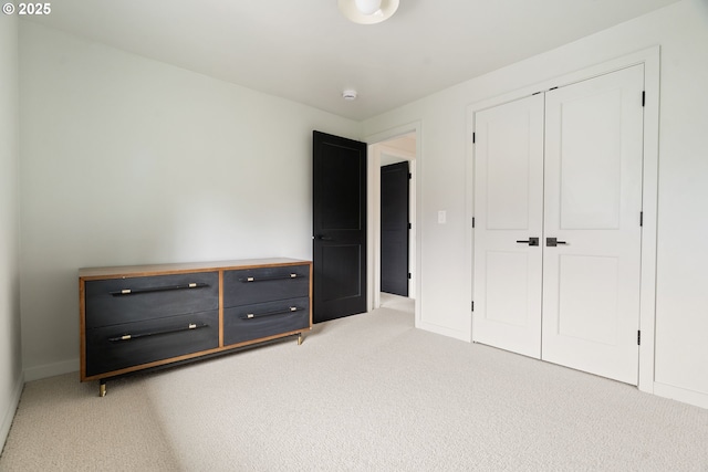 unfurnished bedroom featuring a closet, baseboards, and carpet flooring