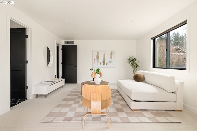 living area with light carpet and visible vents