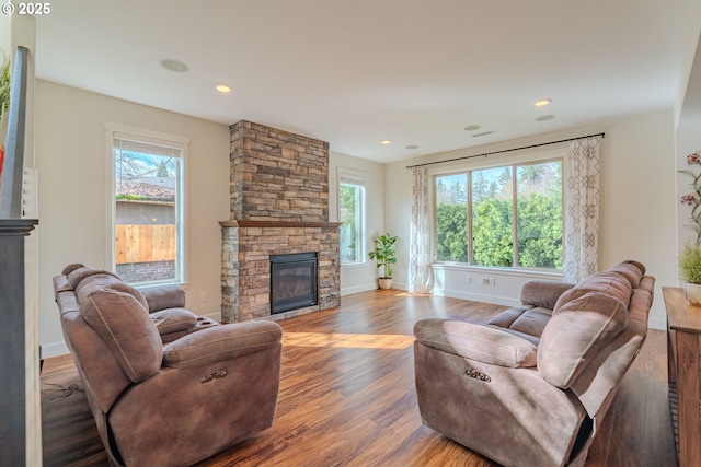 living area featuring recessed lighting, baseboards, wood finished floors, and a fireplace