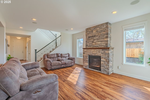 living area featuring a healthy amount of sunlight, stairs, baseboards, and wood finished floors