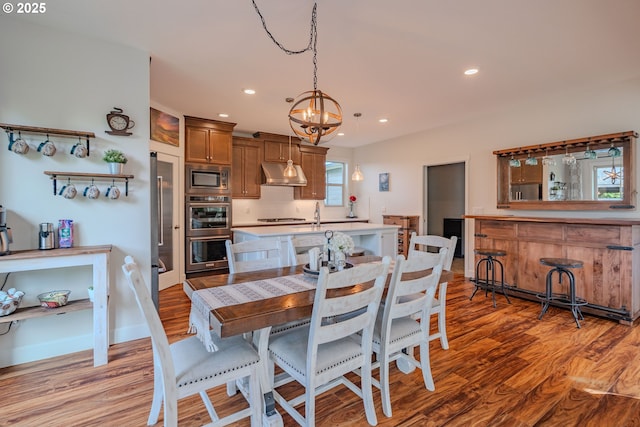 dining room with light wood-style flooring, recessed lighting, and a chandelier