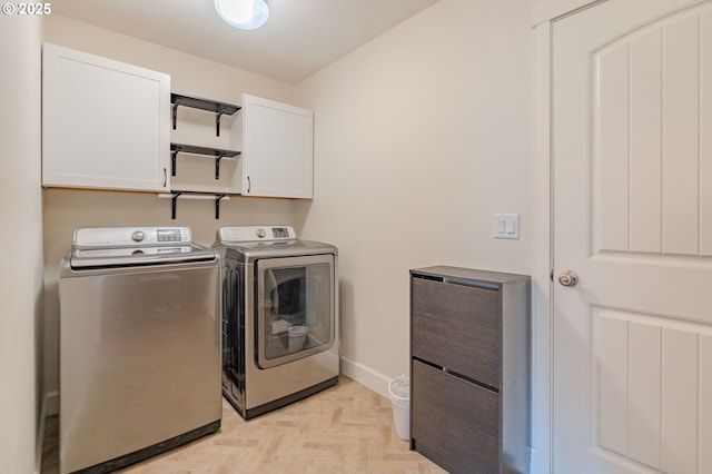 laundry area featuring washing machine and clothes dryer, cabinet space, and baseboards