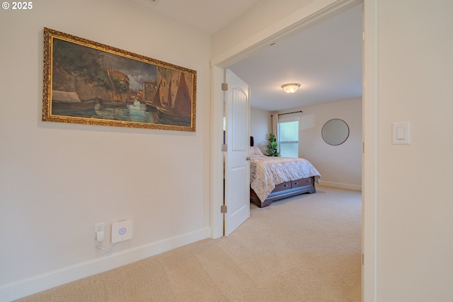 corridor featuring baseboards and carpet