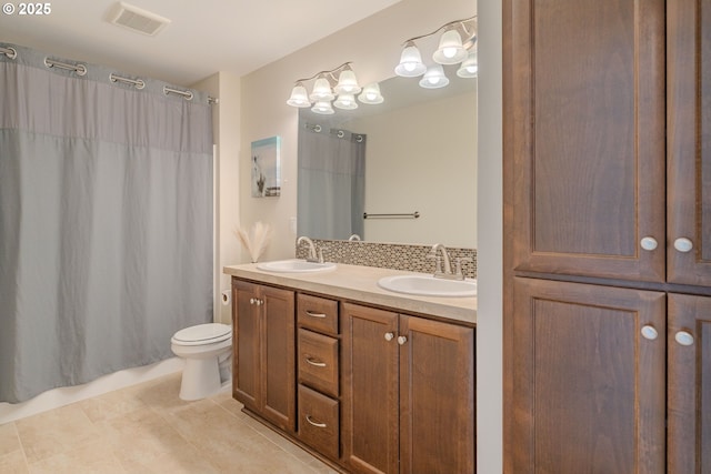 full bath featuring a sink, visible vents, toilet, and double vanity