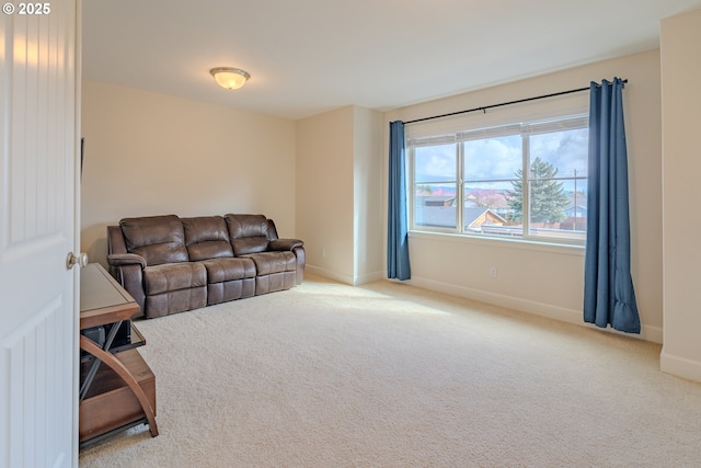 carpeted living area with baseboards