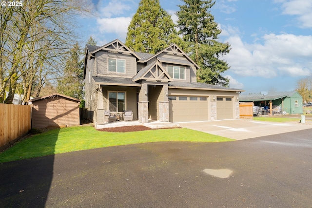 craftsman inspired home featuring driveway, fence, roof with shingles, a front yard, and an attached garage