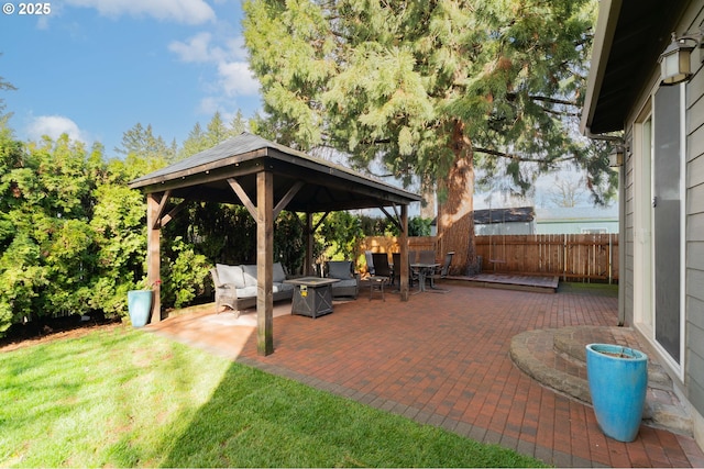 view of patio with a gazebo, an outdoor living space with a fire pit, and fence