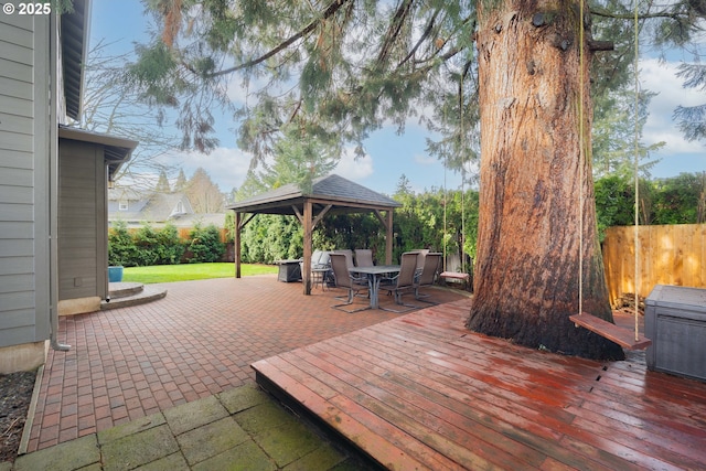 view of patio featuring outdoor dining space, a gazebo, fence, and a wooden deck