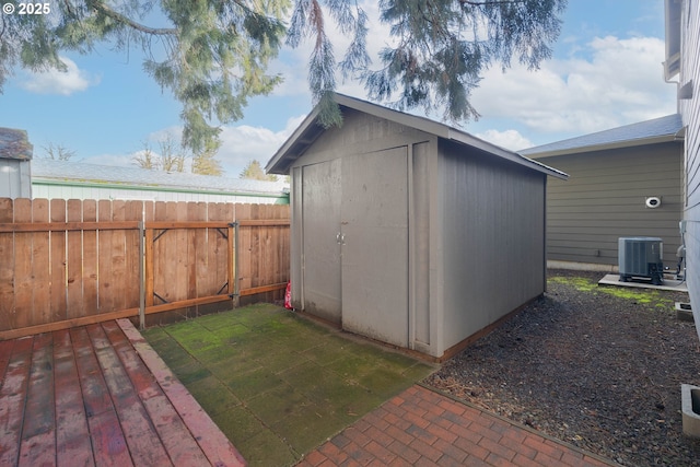 view of shed with central AC unit and a fenced backyard